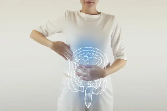 Frau hält Hände auf den Bauch, überlagert von einer grafischen Darstellung des Darms.