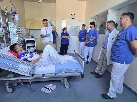 Eine Gruppe von Ärzten steht an einem Patientenbett.