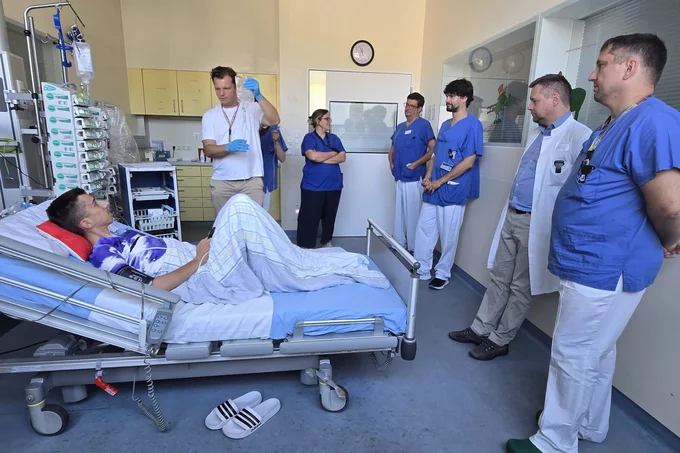 Eine Gruppe von Ärzten steht an einem Patientenbett.