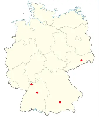 Karte von Deutschland mit hervorgehobenen Punkten in verschiedenen Regionen. Drei rote Punkte markieren spezifische Standorte im südlichen und östlichen Teil des Landes. Der Hintergrund ist in hellem Beige gehalten, ohne weitere Details.