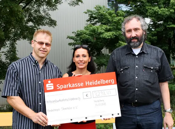 Rolf Schmitt (rechts) und Michael Zepp überreichen Beate Däuwel vom Kinderhospiz Sterntaler e.V. den Spendenscheck in Höhe von 3.298,47 Euro. (
