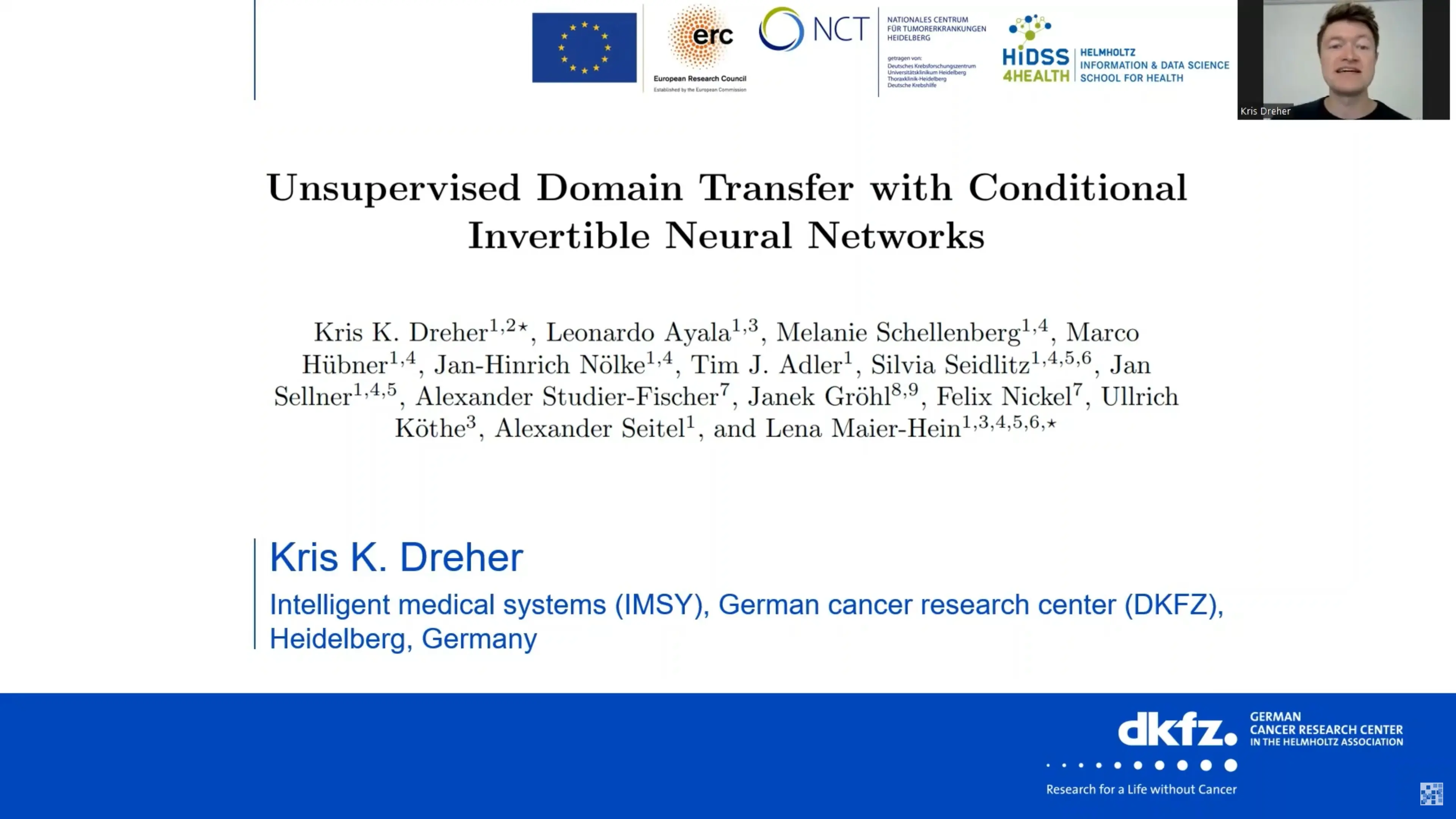 The image displays a presentation slide titled "Unsupervised Domain Transfer with Conditional Invertible Neural Networks," authored by Kris K. Dreher and others. It includes affiliations to various institutions, including the German Cancer Research Center. A speaker is visible in the upper right corner.