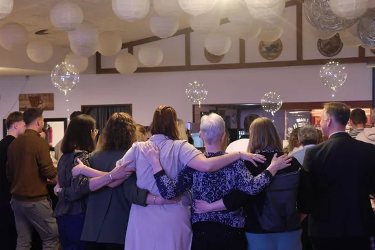 Participants at an event organized by Abend fürs Leben e.V. sharing a group hug