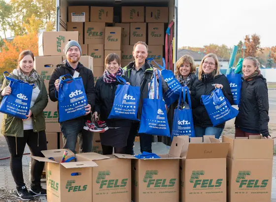 Christian Heinze (second from left) and Karolin Handschuh (left) receive the bags donated by DKFZ staff for refugees at Patrick Henry Village. Also in the picture: Members of DKFZ Asylkreis.