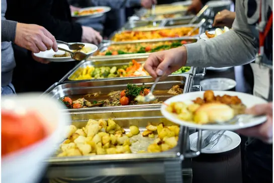 Menschen nehmen Essen vom Buffet.