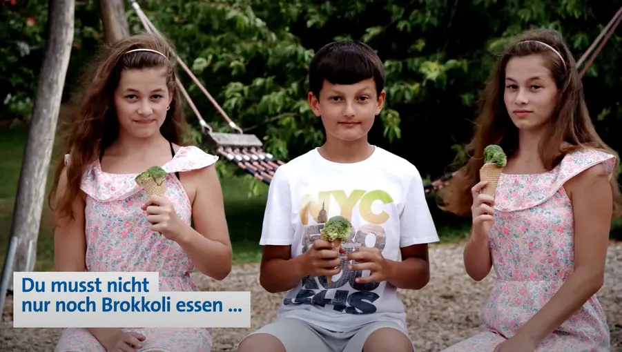 Zwei Mädchen und ein Junge halten Eiswaffeln mit Brokkoli statt Eis; Text unten links: „Du musst nicht nur noch Brokkoli essen …“