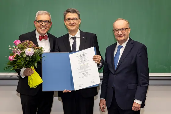 Michael Baumann (Mitte) erhielt die Ehrendoktorwürde der Medizinischen Fakultät Würzburg. Links Dekan Matthias Frosch, rechts Laudator Hermann Einsele.
